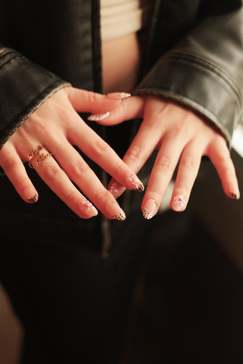 Pink floral press-on nails styled with a black leather jacket