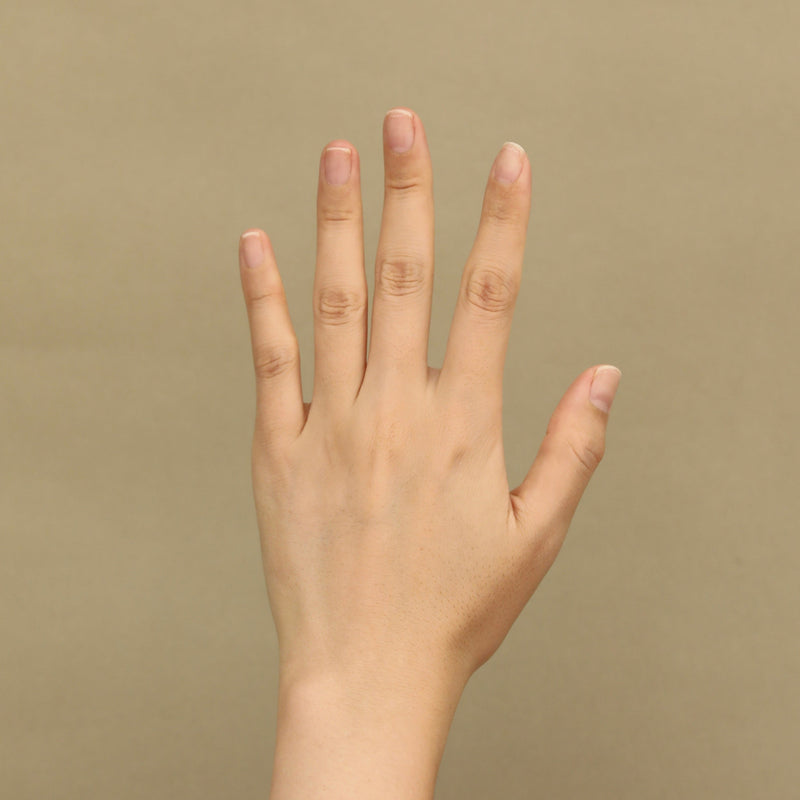 Hand with bare fingers on a beige background before applying the press-on nails
